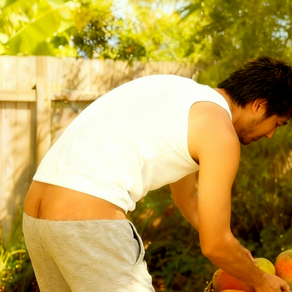 My co-worker's relative with his jogger pants sagging and buttcrack showing putting the papayas in the basket.