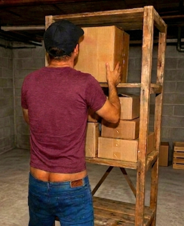 The cleaner with his pants sagging and buttcrack showing arranging boxes on the rack.